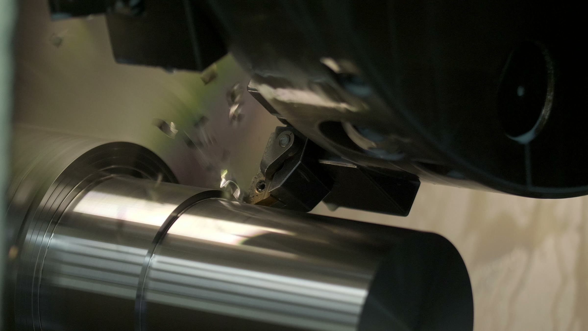 A cutting tool machining a rotating metal shaft
